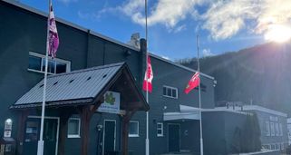 The Canadian Flag and Ontario Flag flying at half mast in front of the A.J. LaRue Community Centre.